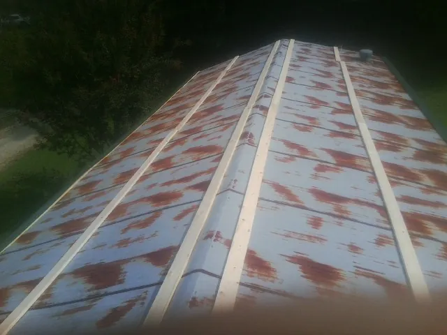 Rusted metal roof panels with new wood purlins before replacement — Storm Damage Roof Repair in Benton by Roofing Brothers